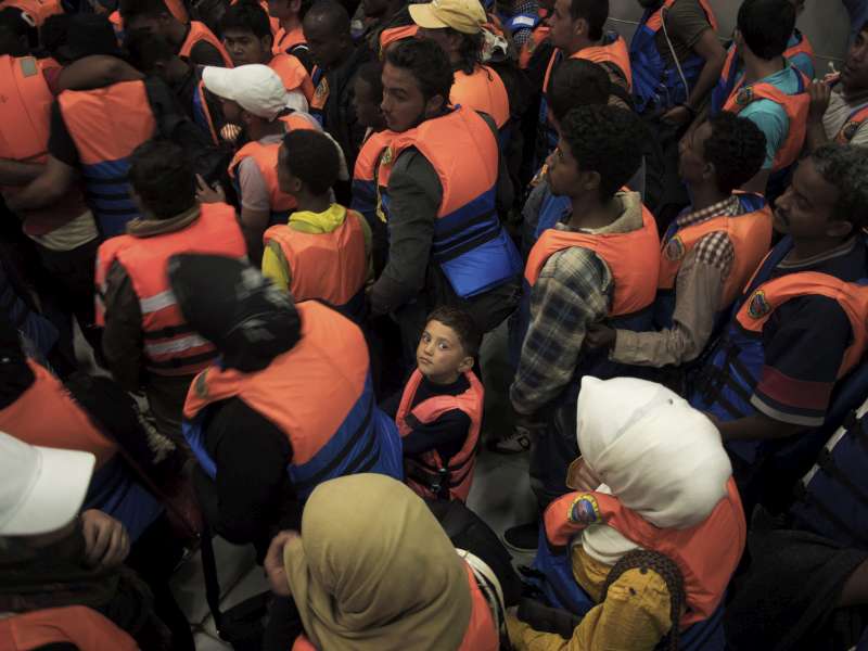 Un bambino in mezzo a un gruppo di adulti soccorso nel Mediterraneo nel 2014 (foto UNHCR).